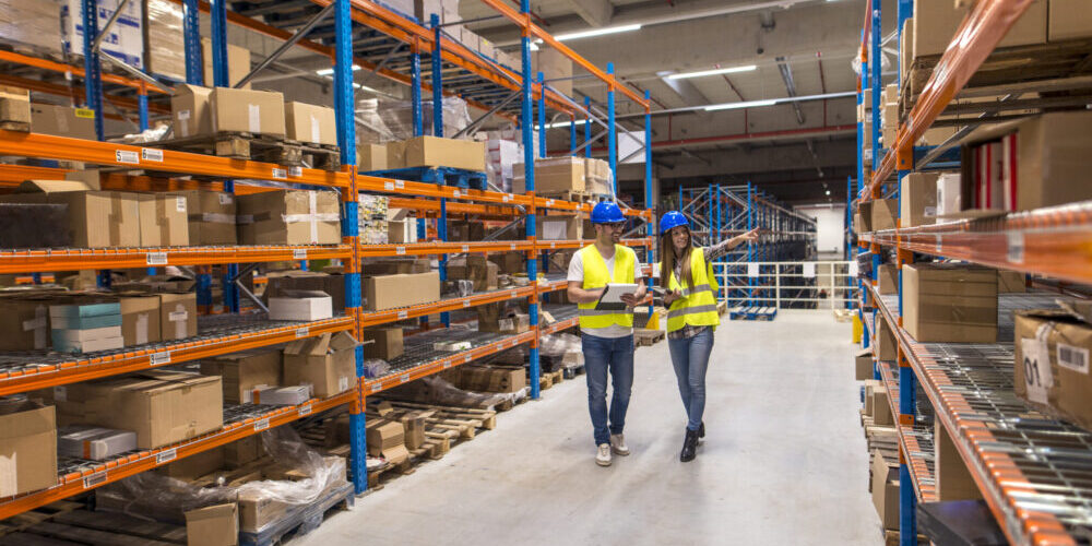 Two warehouse workers walking through distribution storage area – discussing logistics, inventory organization, and Easylife Tech supply chain operations